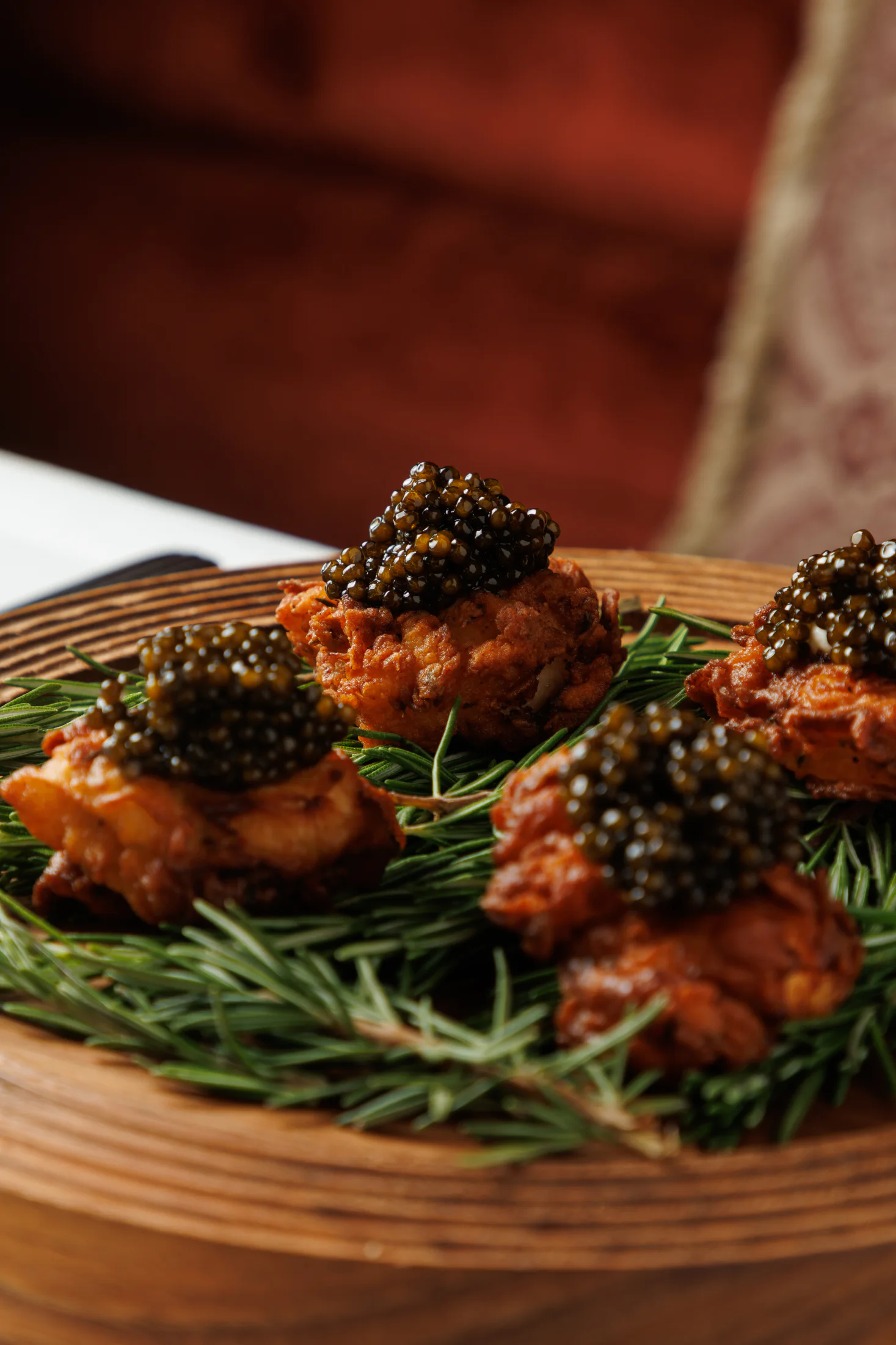 Caviar-topped fritters on rosemary